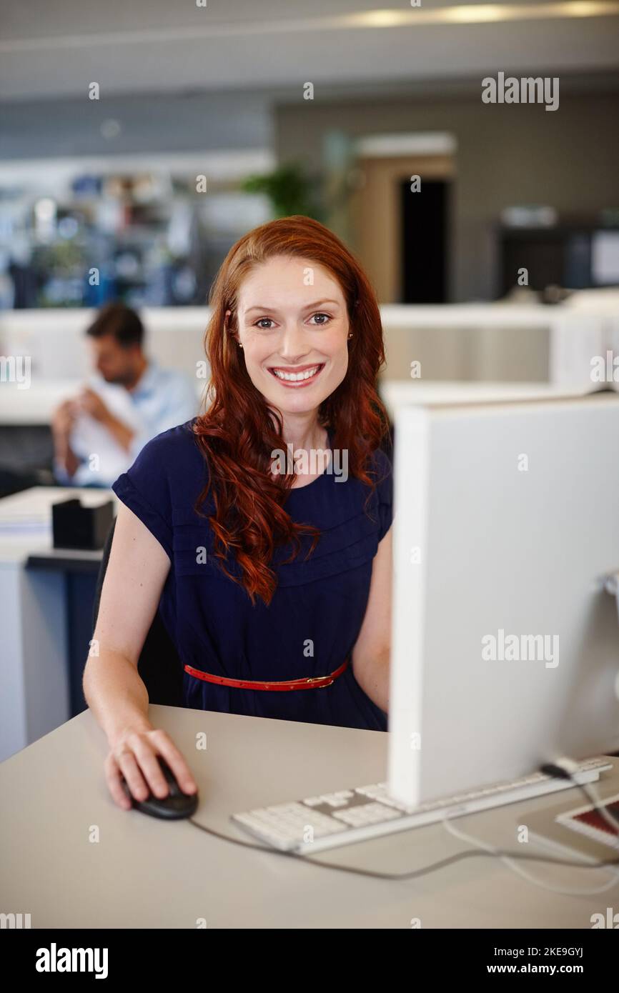 Confident in the calibre of my work. Portrait of a happy businesswoman using a computer at her work desk. Stock Photo