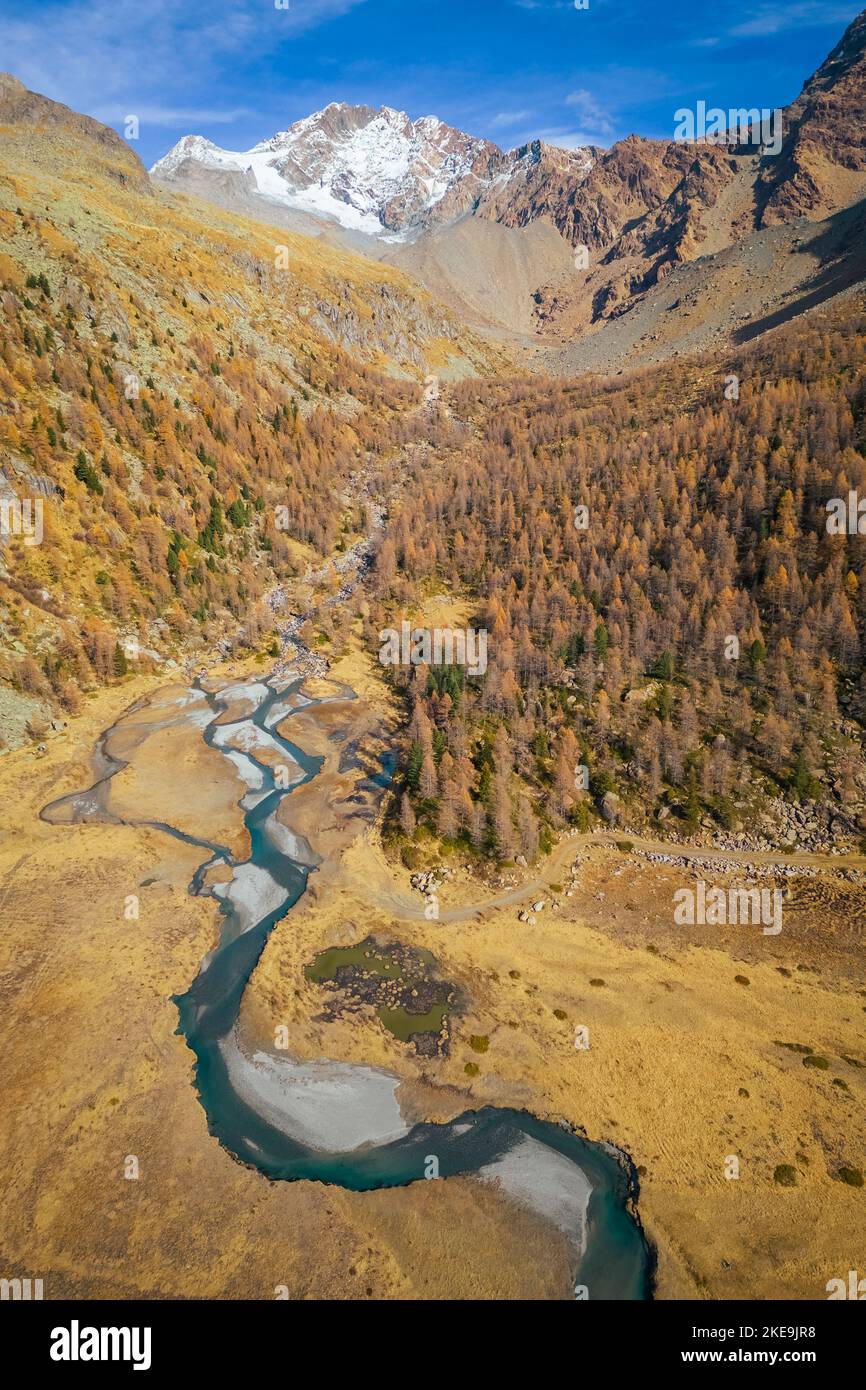 Aerial view of Preda Rossa valley in autumn in front of  Monte Disgrazia and Corni Bruciati. Val Masino, Sondrio province, Lombardy, Italy. Stock Photo