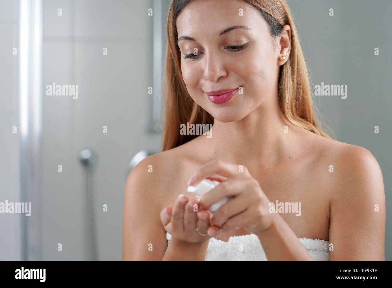 Skin care woman applying cream with retinol anti-signs in the bathroom Stock Photo