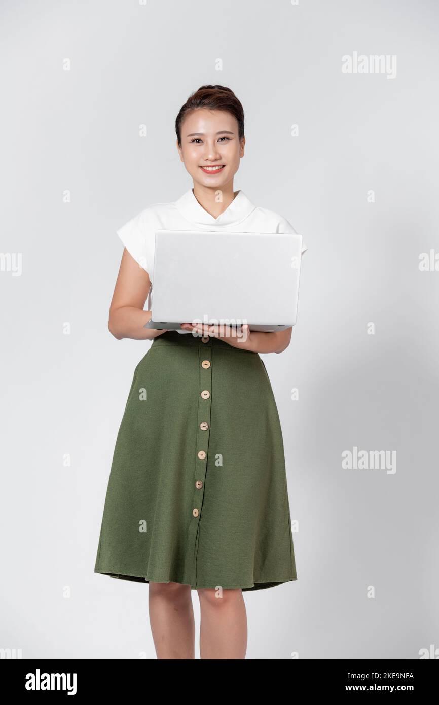 Portrait of happy young asian girl using laptop computer isolated over ...