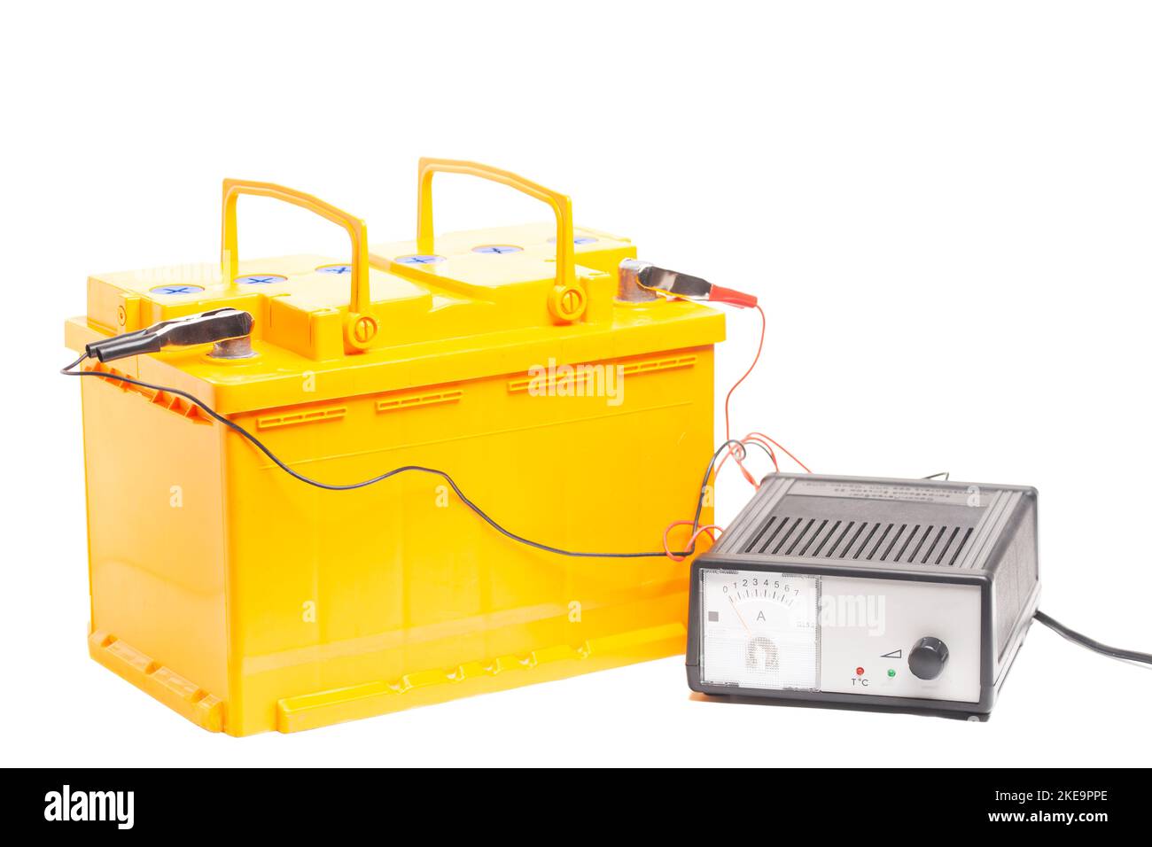 yellow car battery with car battery charger isolated on white background. Stock Photo