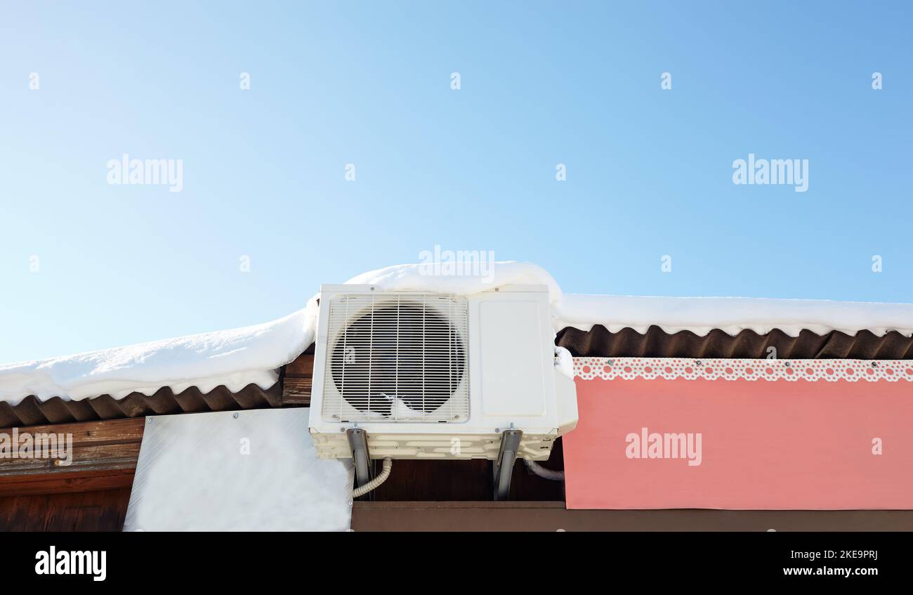 Snow covered invertor Air conditioner outdoor unit closeup on roof top