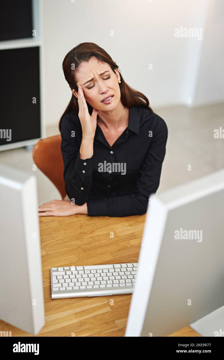 When work stress strikes. a young businesswoman having a bad day at work. Stock Photo