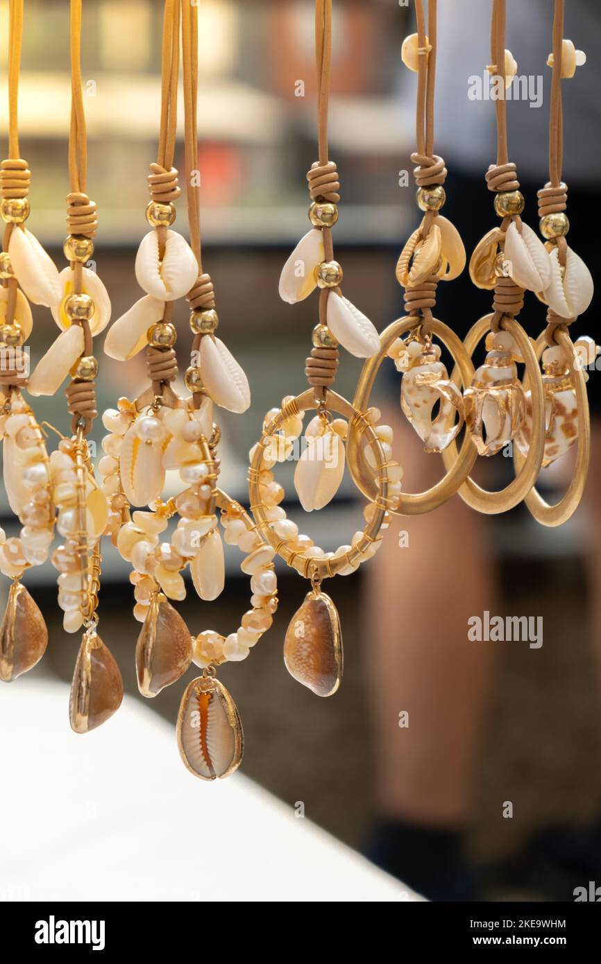 Jewelery showcase sea decorations on street market. Woman choosing