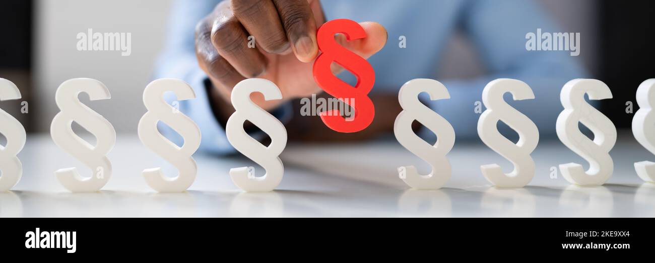 Businessperson's Hand Holding Paragraph Symbol. Legal Court Stock Photo