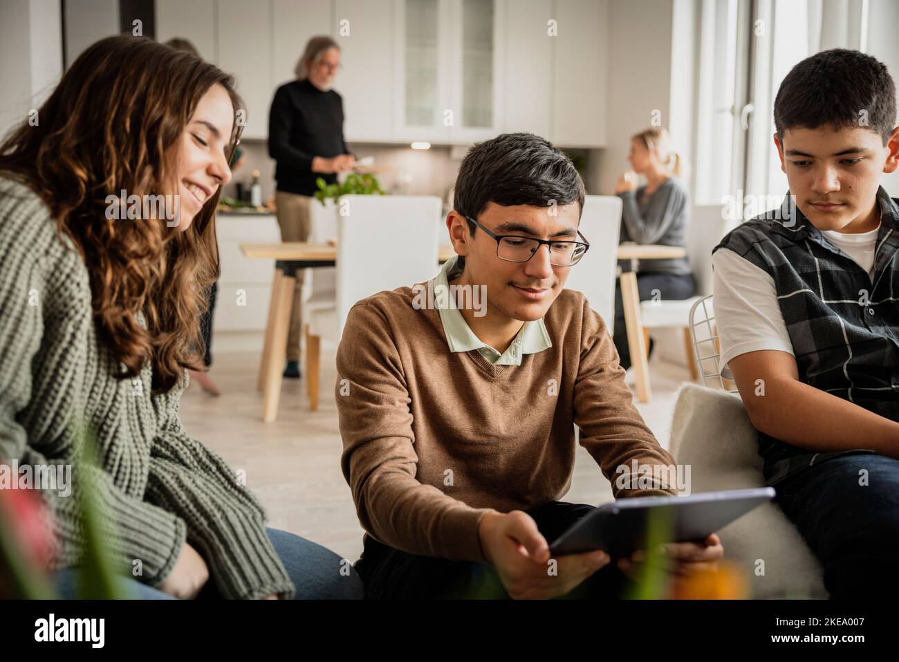 Siblings using digital tablet at home Stock Photo
