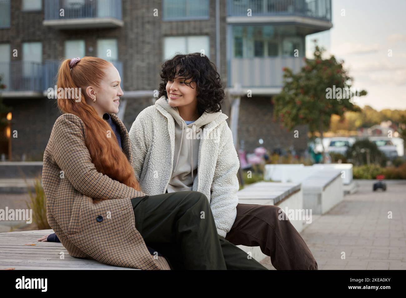 Young friends sitting outdoors hi-res stock photography and images - Alamy