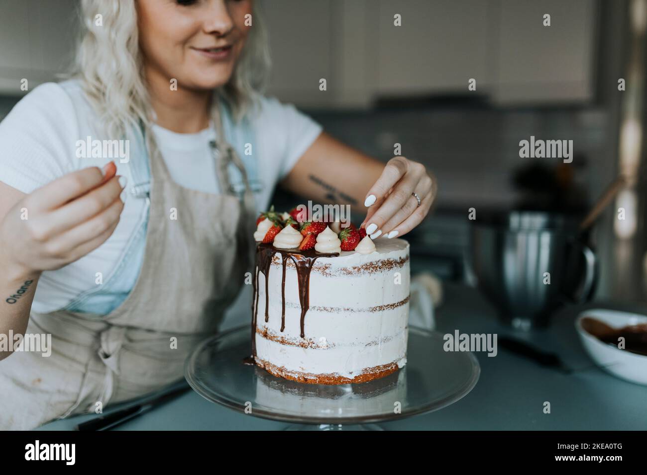 Woman in kitchen decorating cake Stock Photo