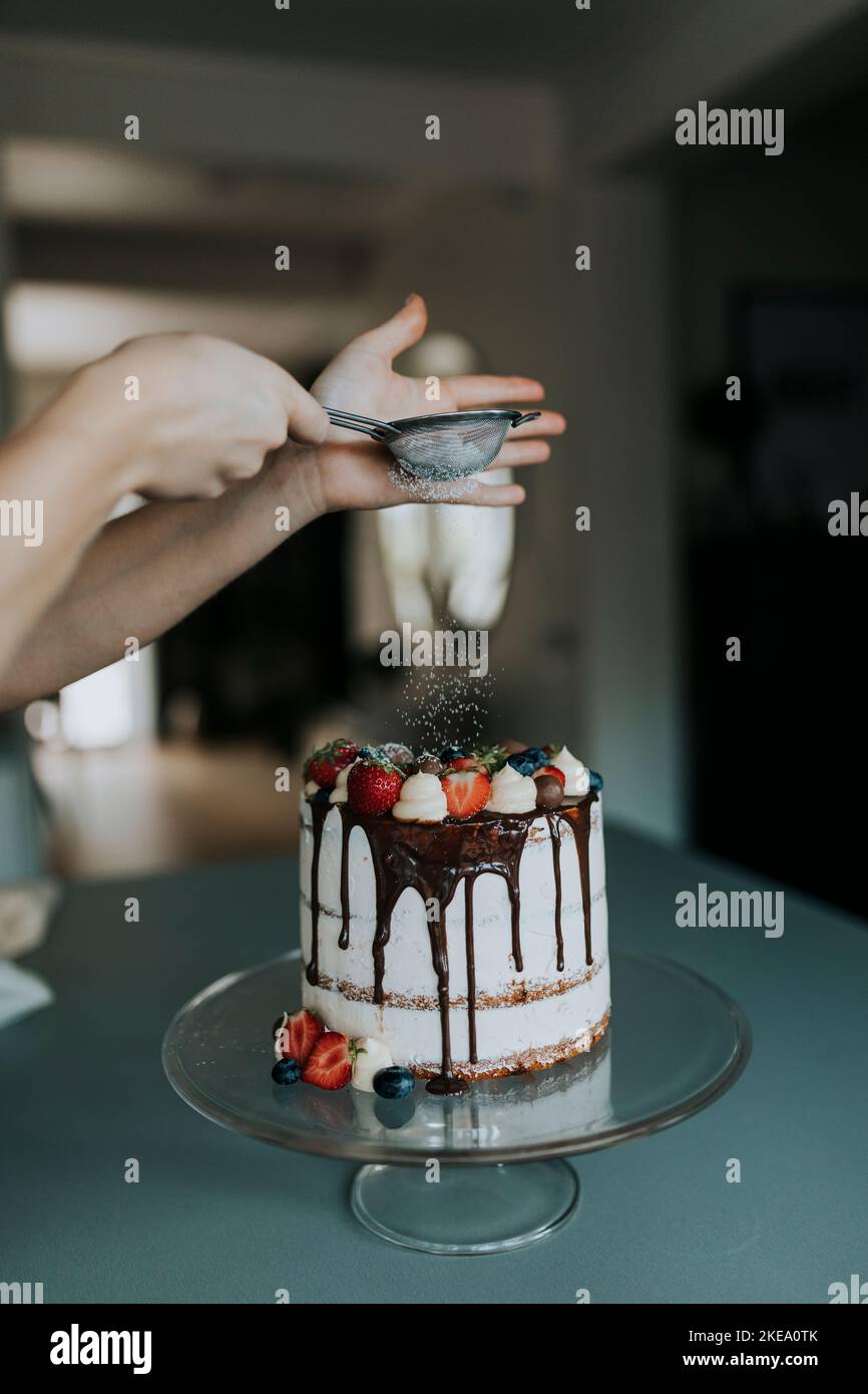 Woman in kitchen decorating cake Stock Photo