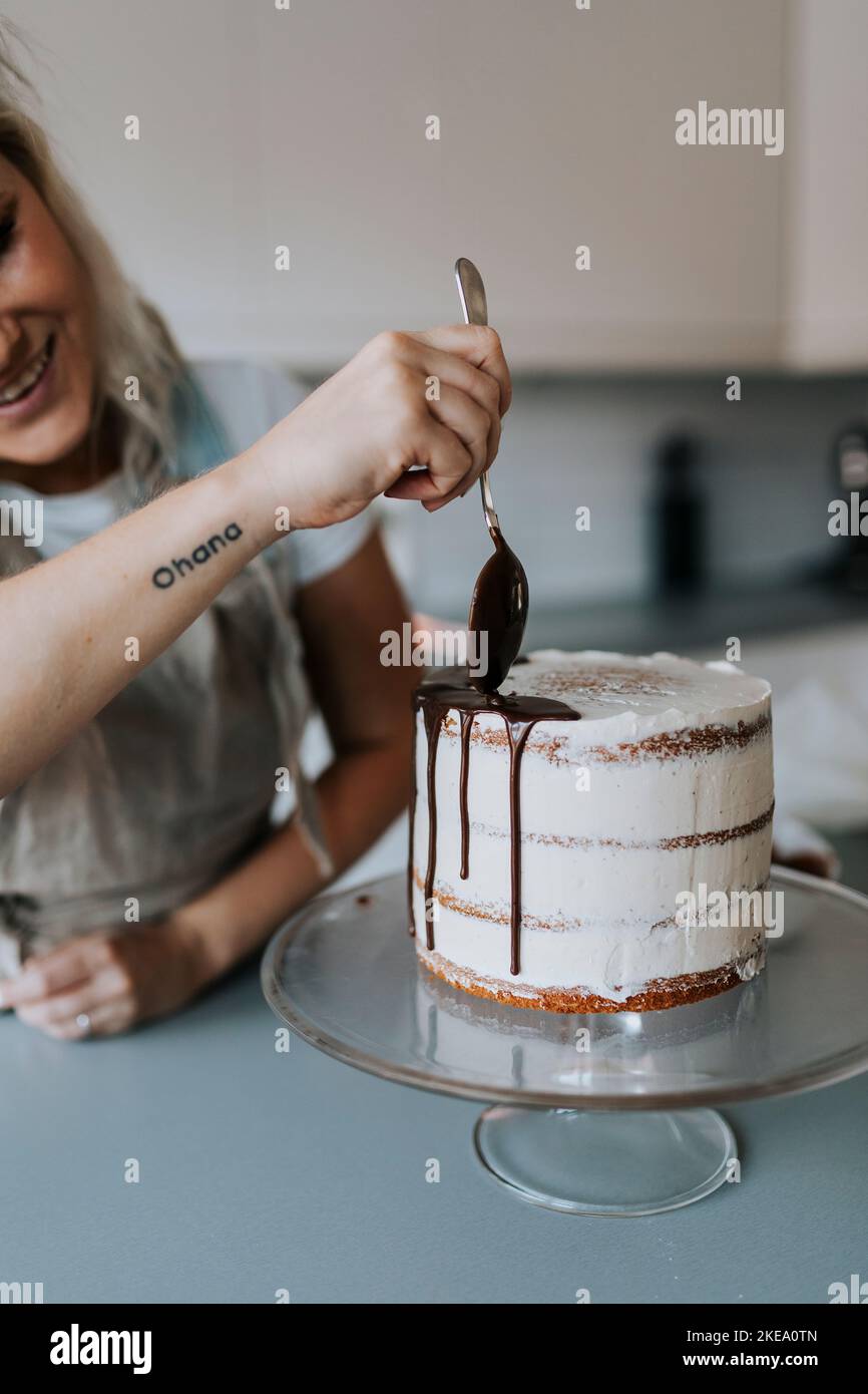 Woman in kitchen decorating cake Stock Photo
