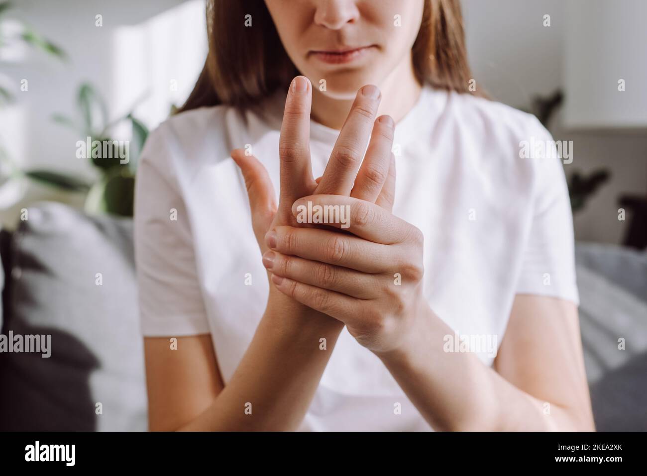 Sad girl massage hand with wrist pain, rheumatoid arthritis concept