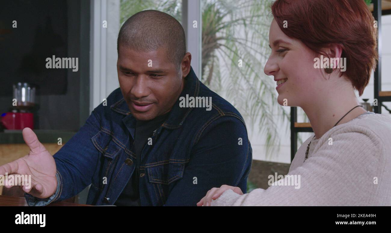 African American manager explaining job to new young female employee in ...