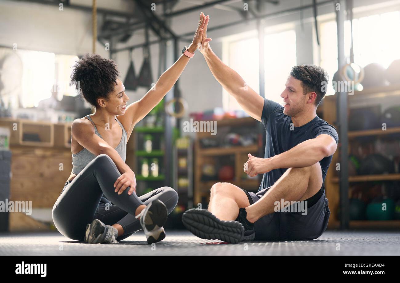 High five, motivation and fitness with a man and woman celebrating as a ...