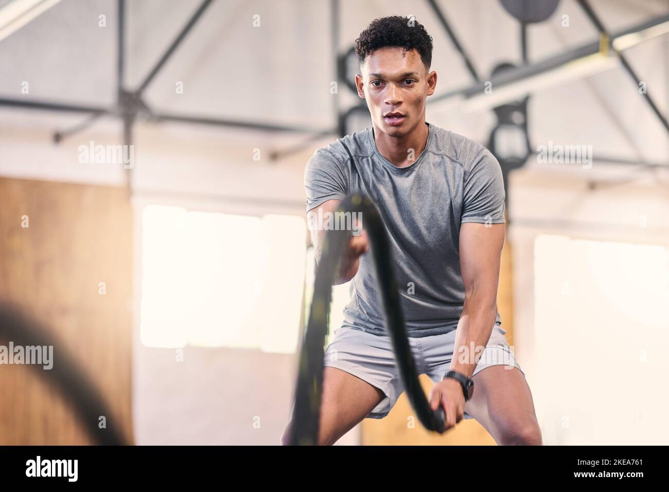 Gym battle ropes, training and black man athlete in a cardio, workout ...