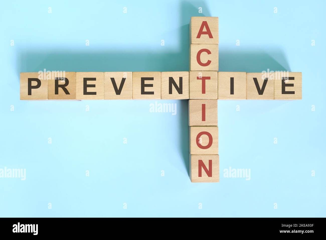 Preventive action business concept.  Wooden blocks crossword puzzle flat lay. Stock Photo