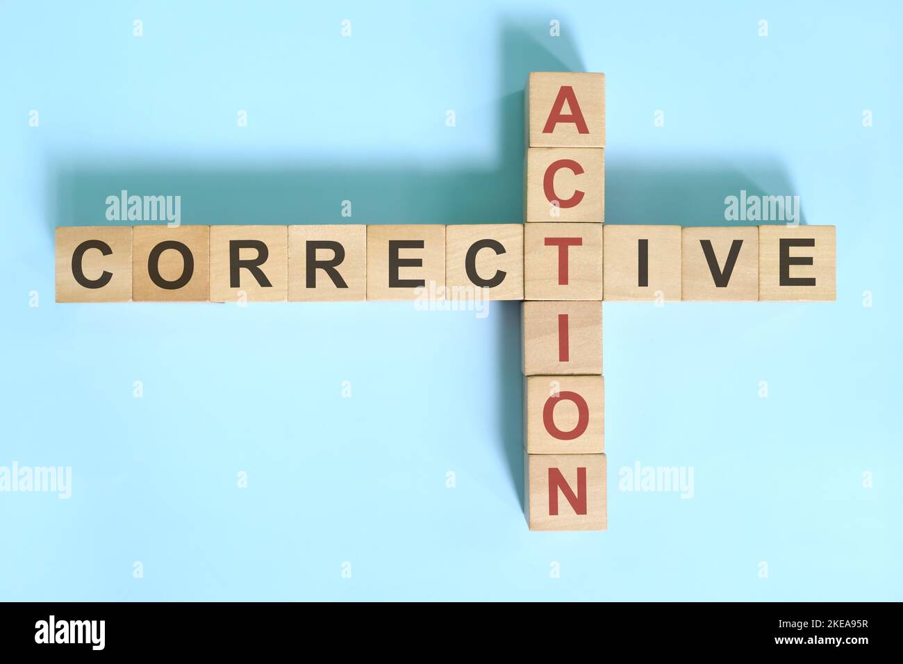 Corrective action business concept. Wooden blocks crossword puzzle flat lay. Stock Photo