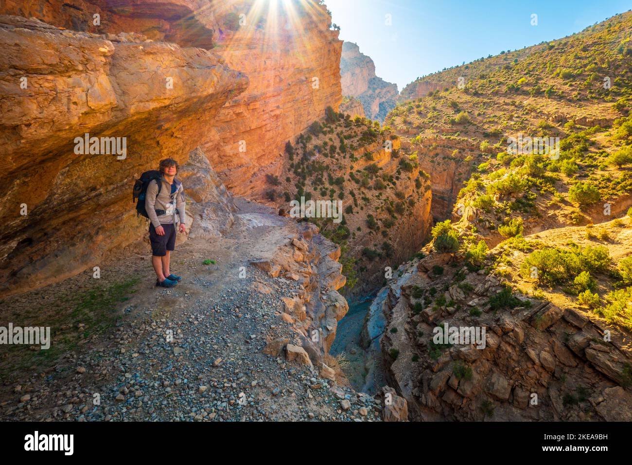 A trekker on a man made stairway up the canyon side of the M'Goun Gorge in the Atlas mountains of Morocco Stock Photo