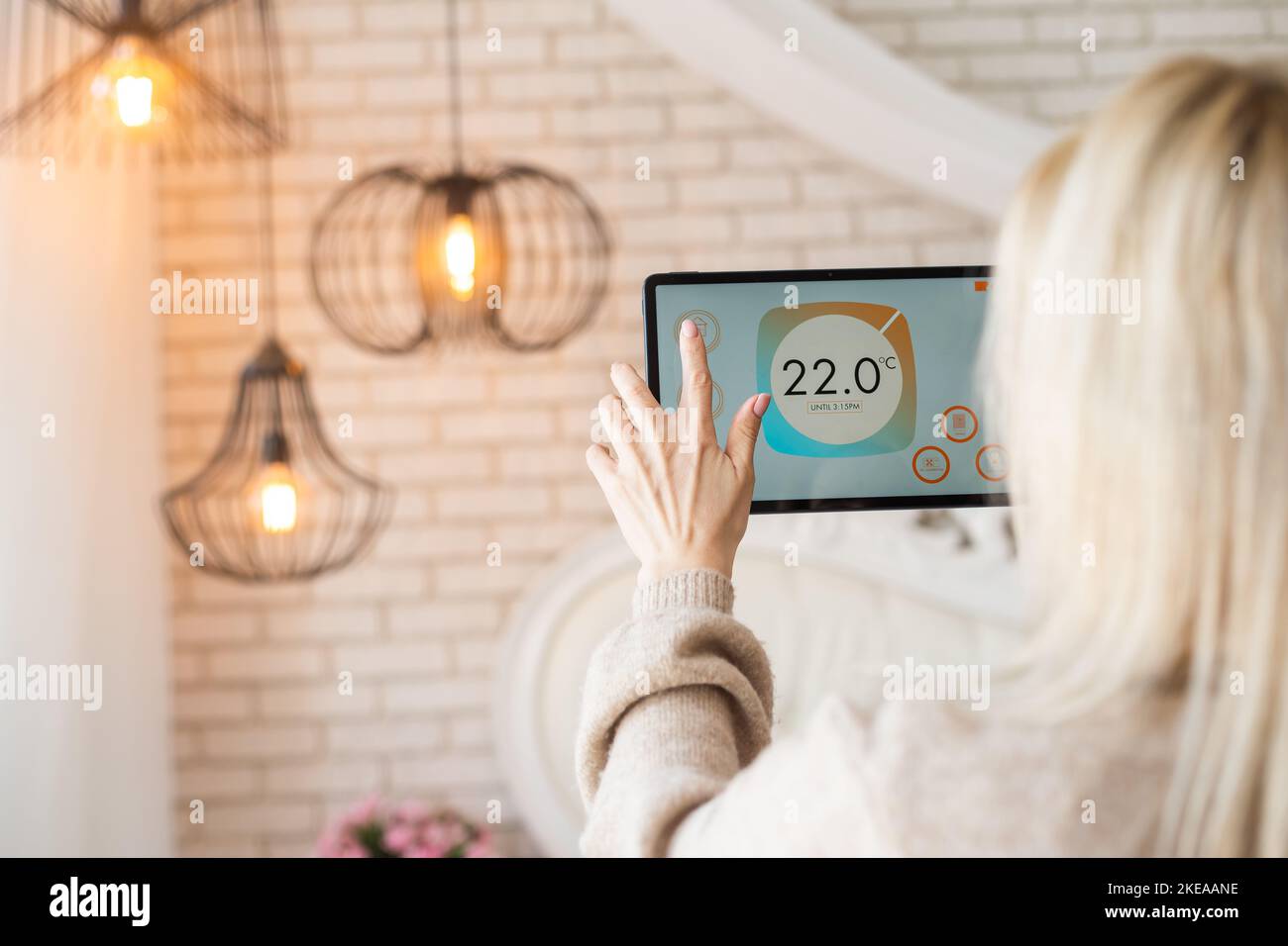 Woman controlling smart home devices using a digital tablet with ...