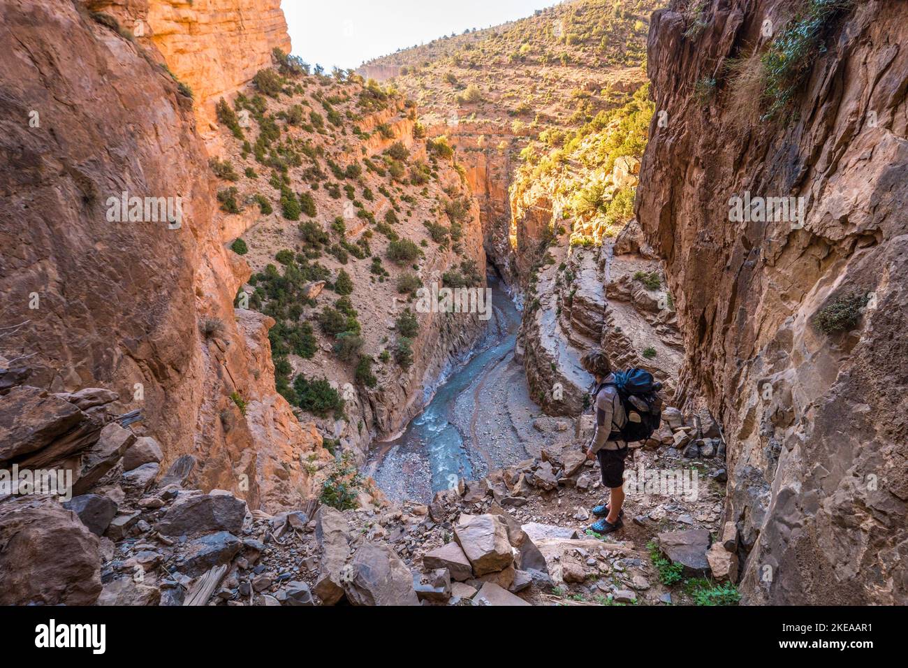 A trekker on a man made stairway up the canyon side of the M'Goun Gorge in the Atlas mountains of Morocco Stock Photo