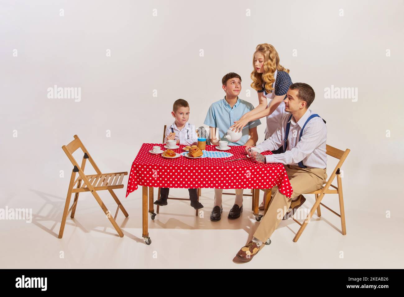Having Table Portrait of young happy family sitting at table together and having ...