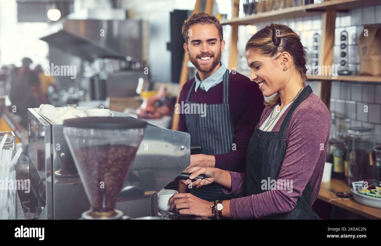 Awesome coffee coming right up. two young baristas operating a coffee