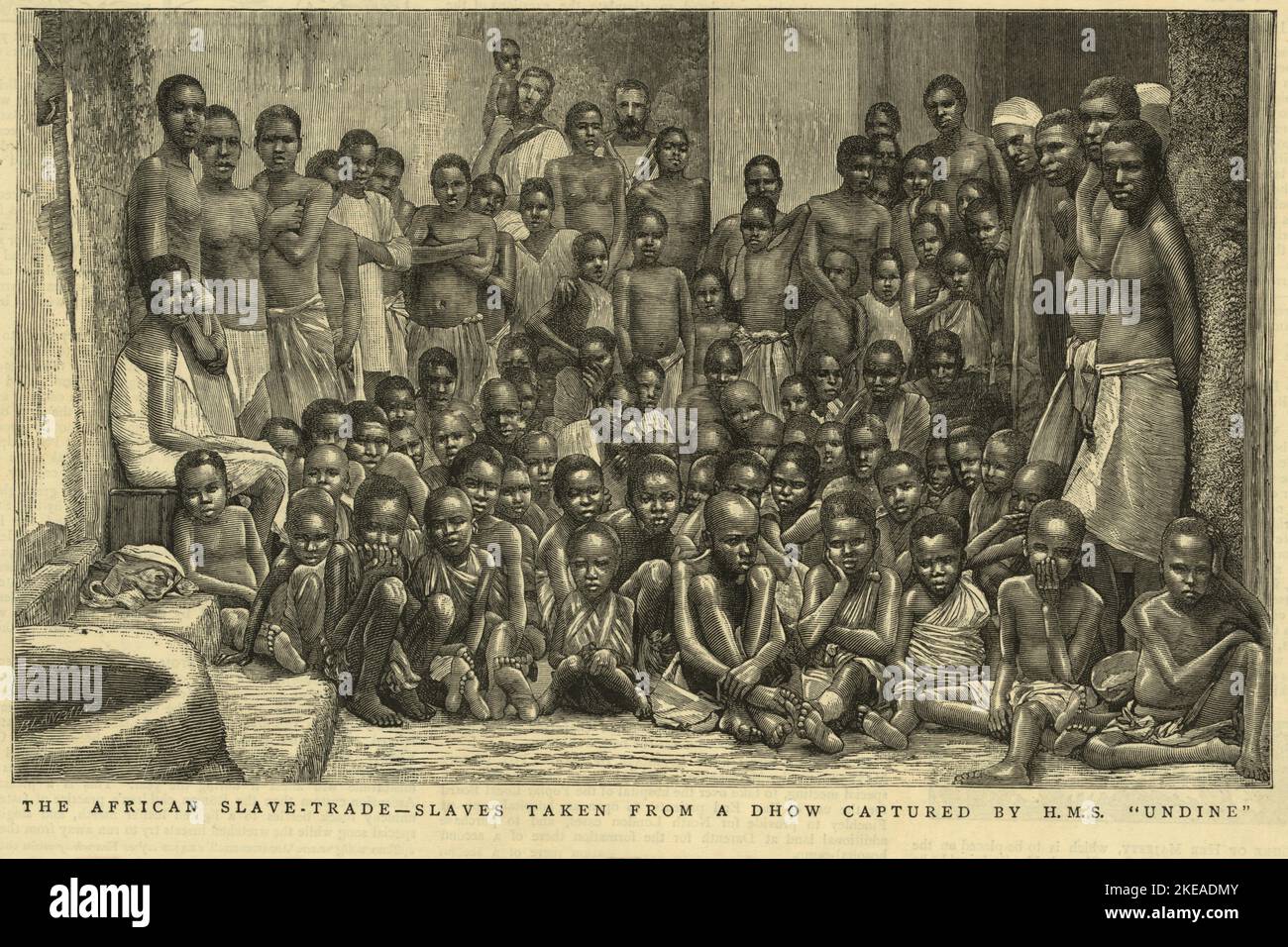 Vintage illustration dated June 7 1884 entitled The African Slave Trade - slaves taken from an Arab dhow captured by HMS Undine. It shows two British sailors posing with African men women and children rescued by the Royal Navy anti slavery patrols in East Africa during the 1880s.  Illustrated in The Graphic. London, June 7, 1884 Stock Photo