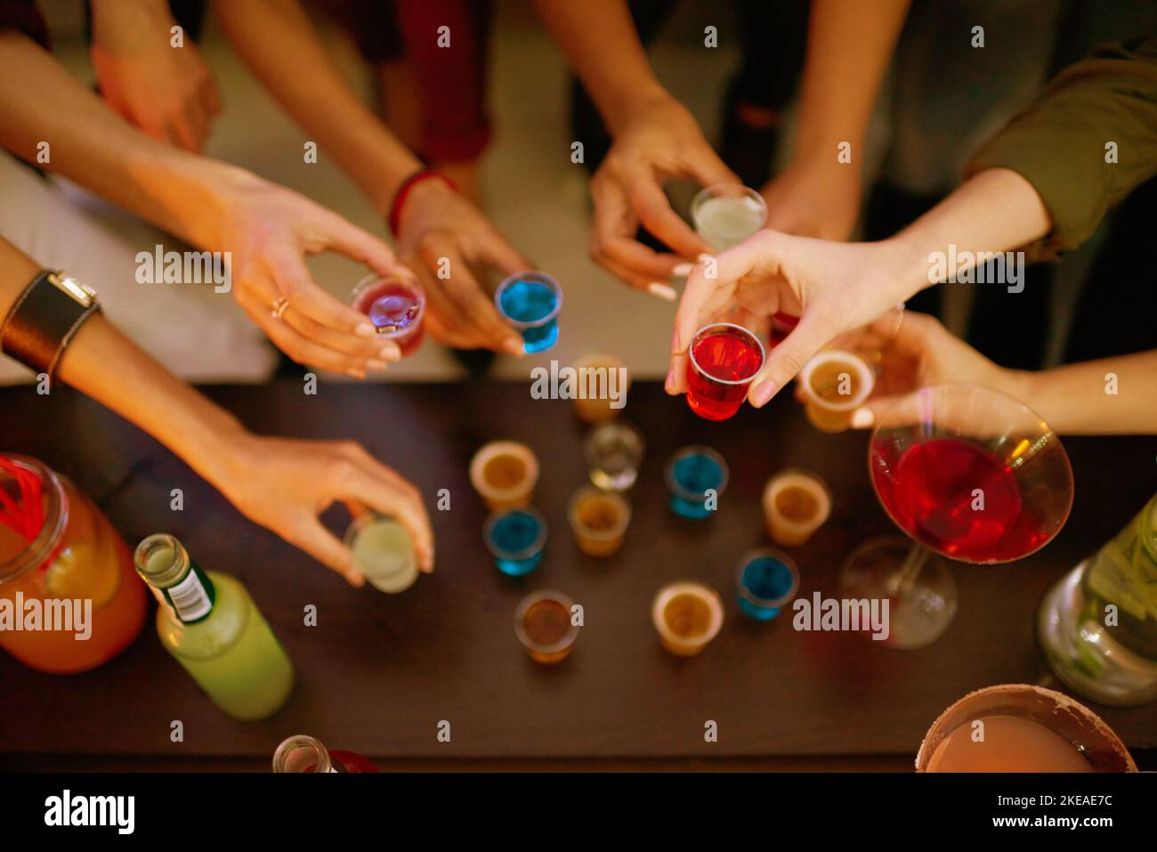 Theres a little taste for everyone. a group of friends having shots at a party. Stock Photo