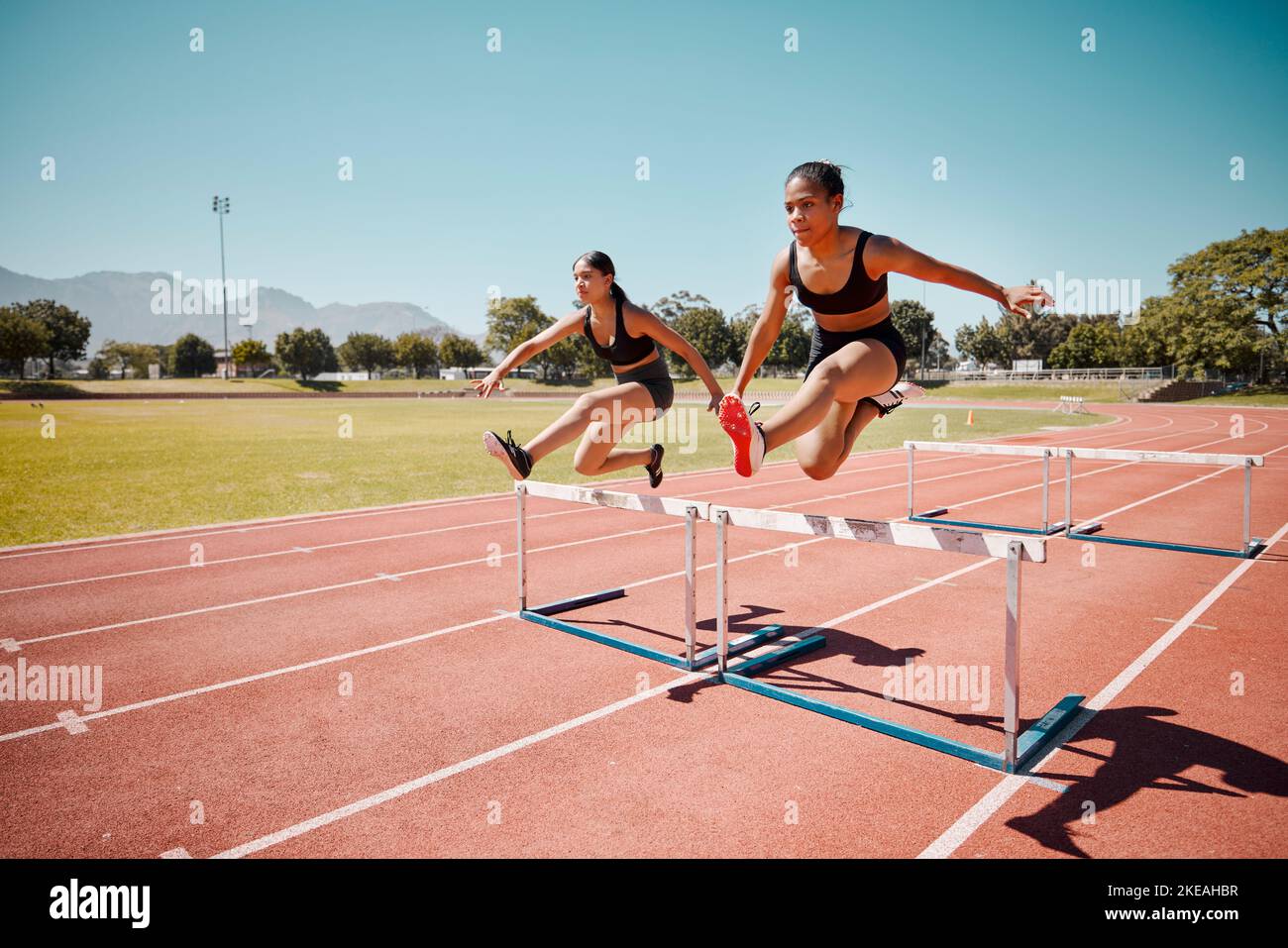 Sport, jump and women runner doing hurdles on stadium track, athlete