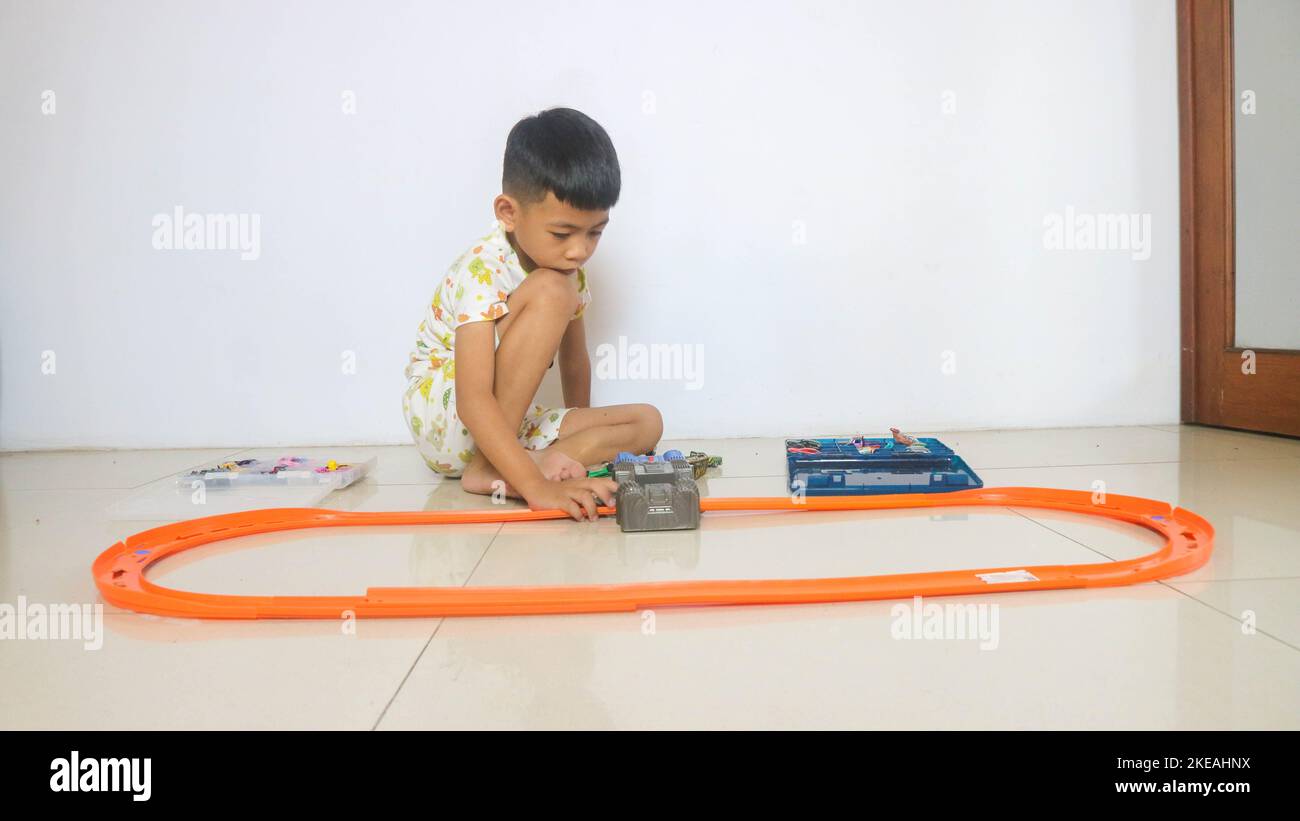a boy playing with a toy car Stock Photo - Alamy