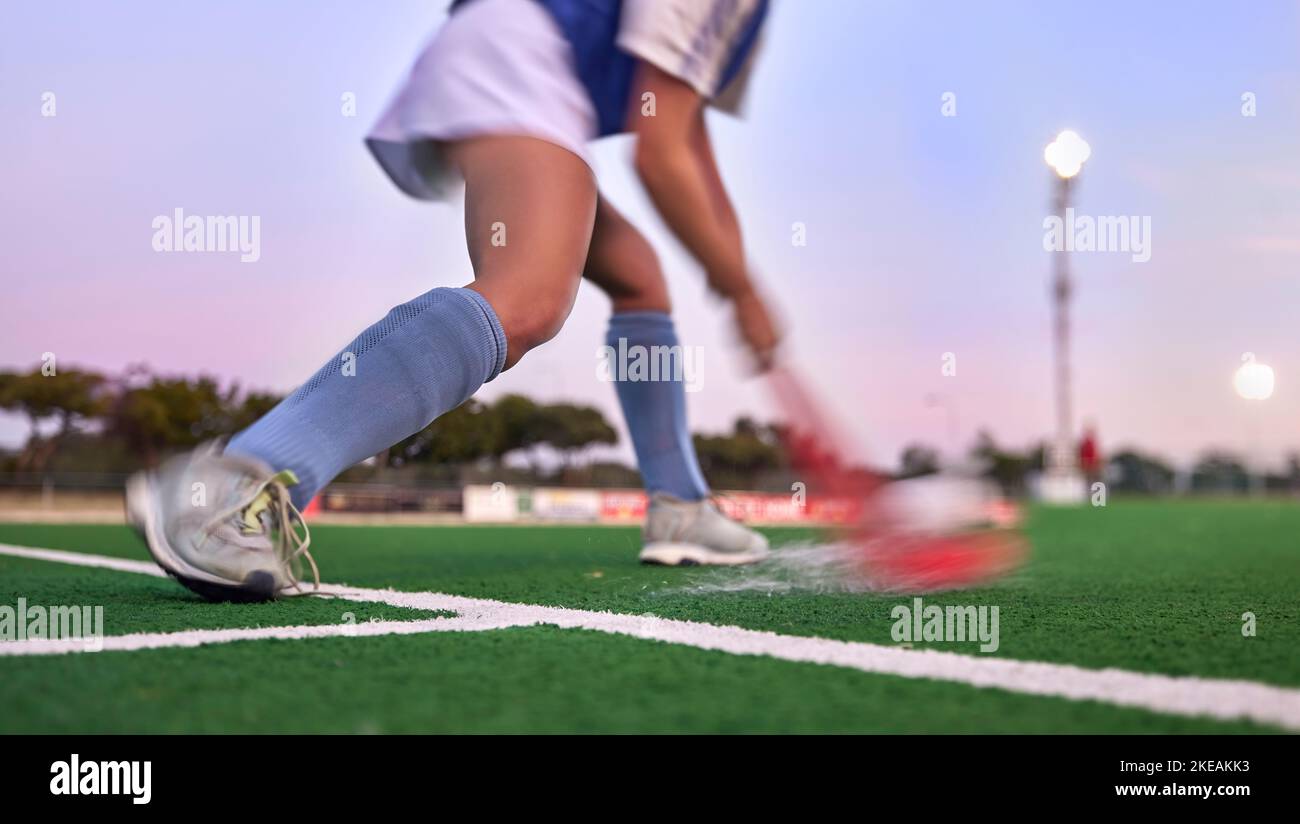Sports, hockey and hit with woman on field for training, fitness and goals exercise. Challenge, action or power with shoes of hockey player in stadium Stock Photo