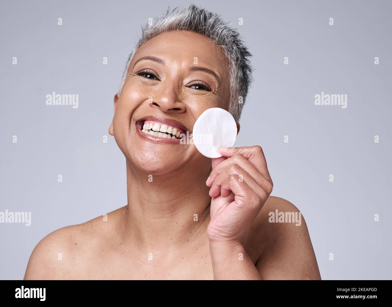 Woman, elderly and beauty portrait with cotton pad for cosmetic, makeup and product removal on face. Cleaning, facial and skincare cleansing model Stock Photo
