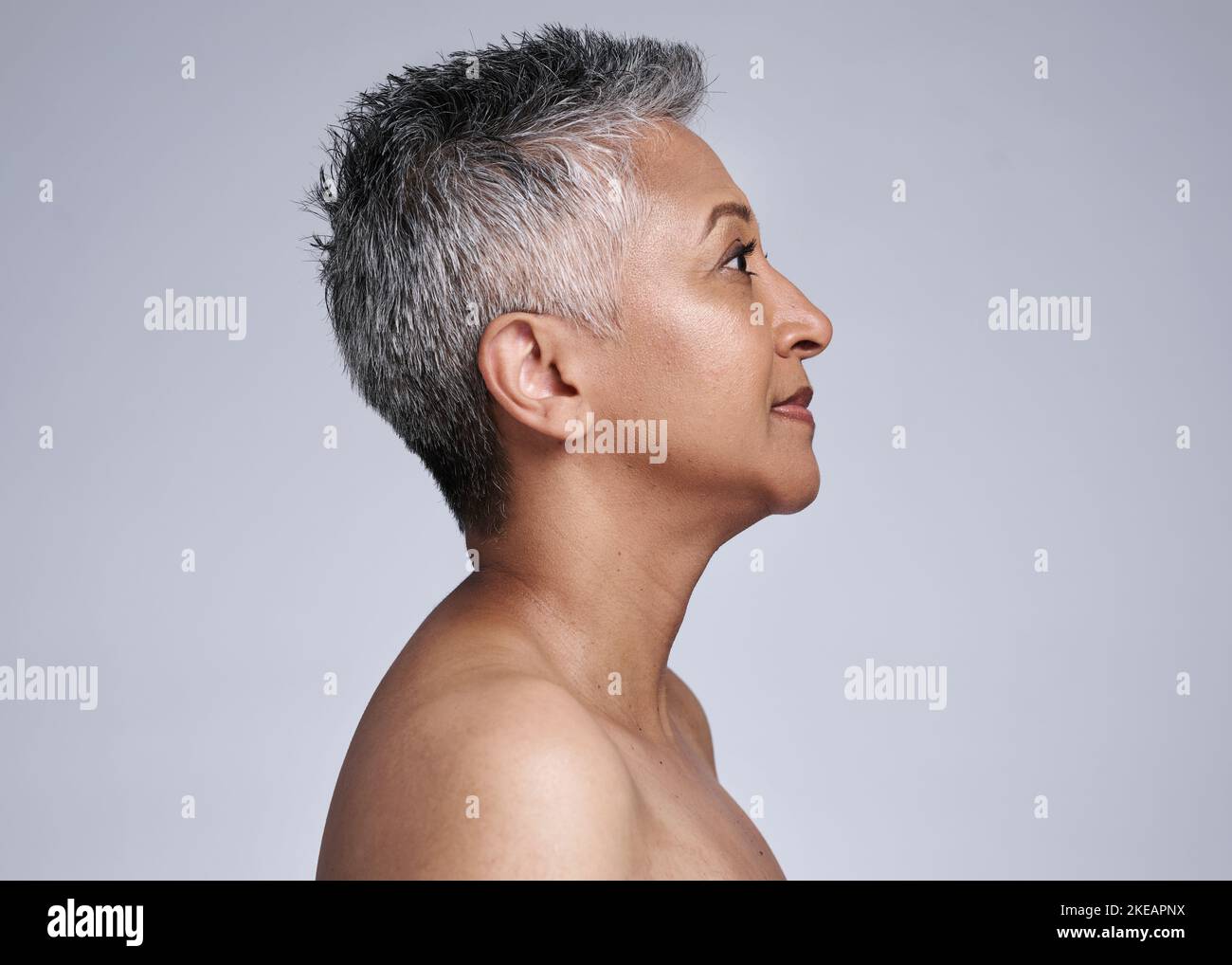 Mature woman, face and skincare glow on gray studio background in plastic surgery, body dermatology or cosmetology preparation. Indian beauty model Stock Photo