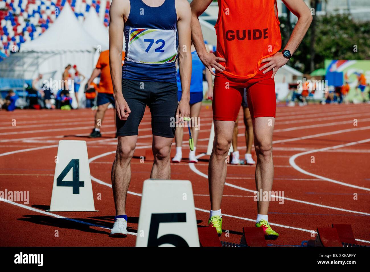 blind male runner with guide running sprint race Stock Photo