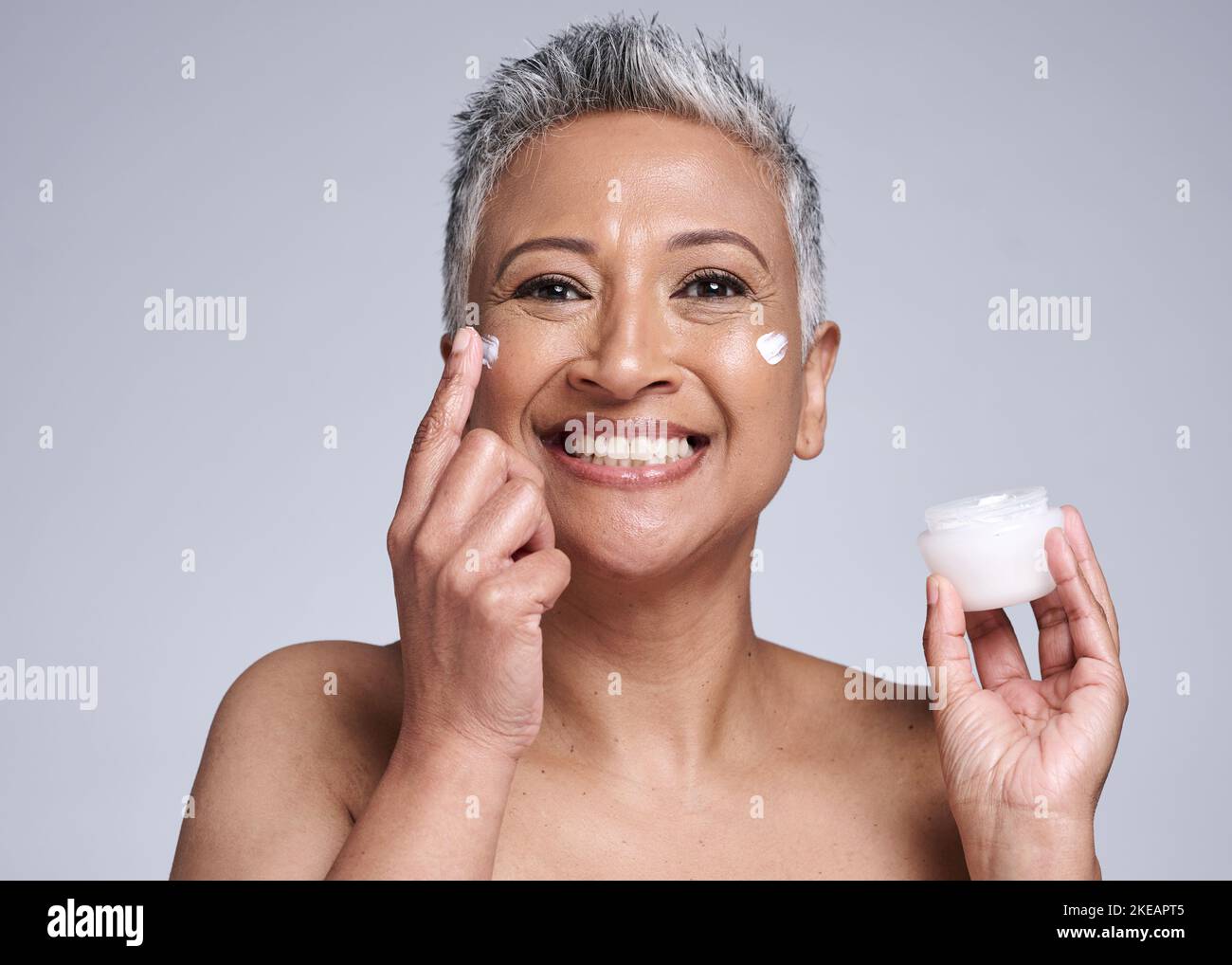 Cream, face and skincare senior woman in studio portrait for healthy glow, wellness and cosmetics promotion, advertising or marketing. Happy anti Stock Photo
