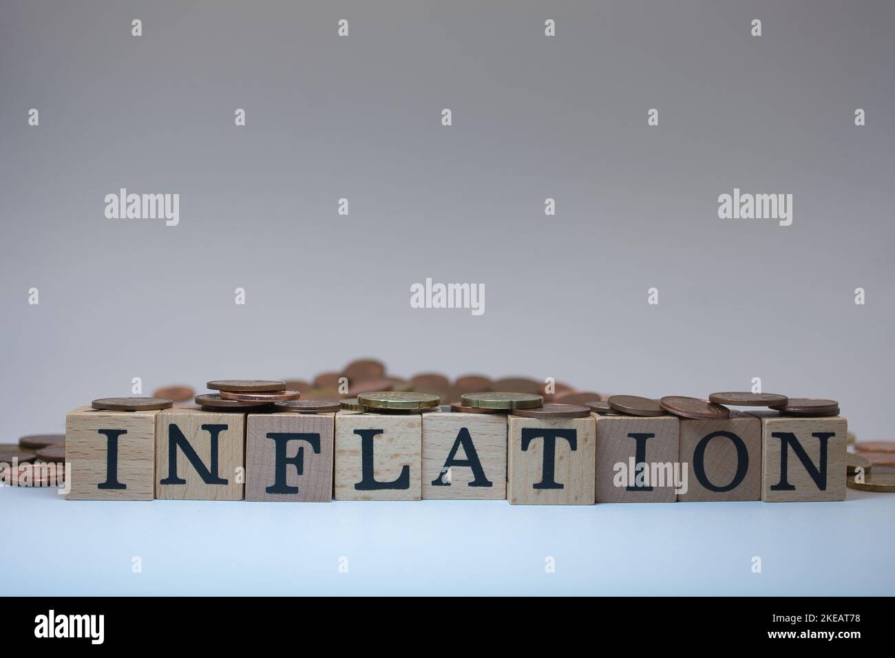 Inflation mit Wuerfel gestellt und umrahmt von Kleingeld Stock Photo