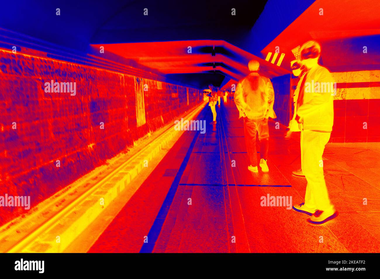 Railway station. Commuter train and passengers on the boarding platform, trainshed. Illustration of thermal image - thermal impressionism. Stock Photo
