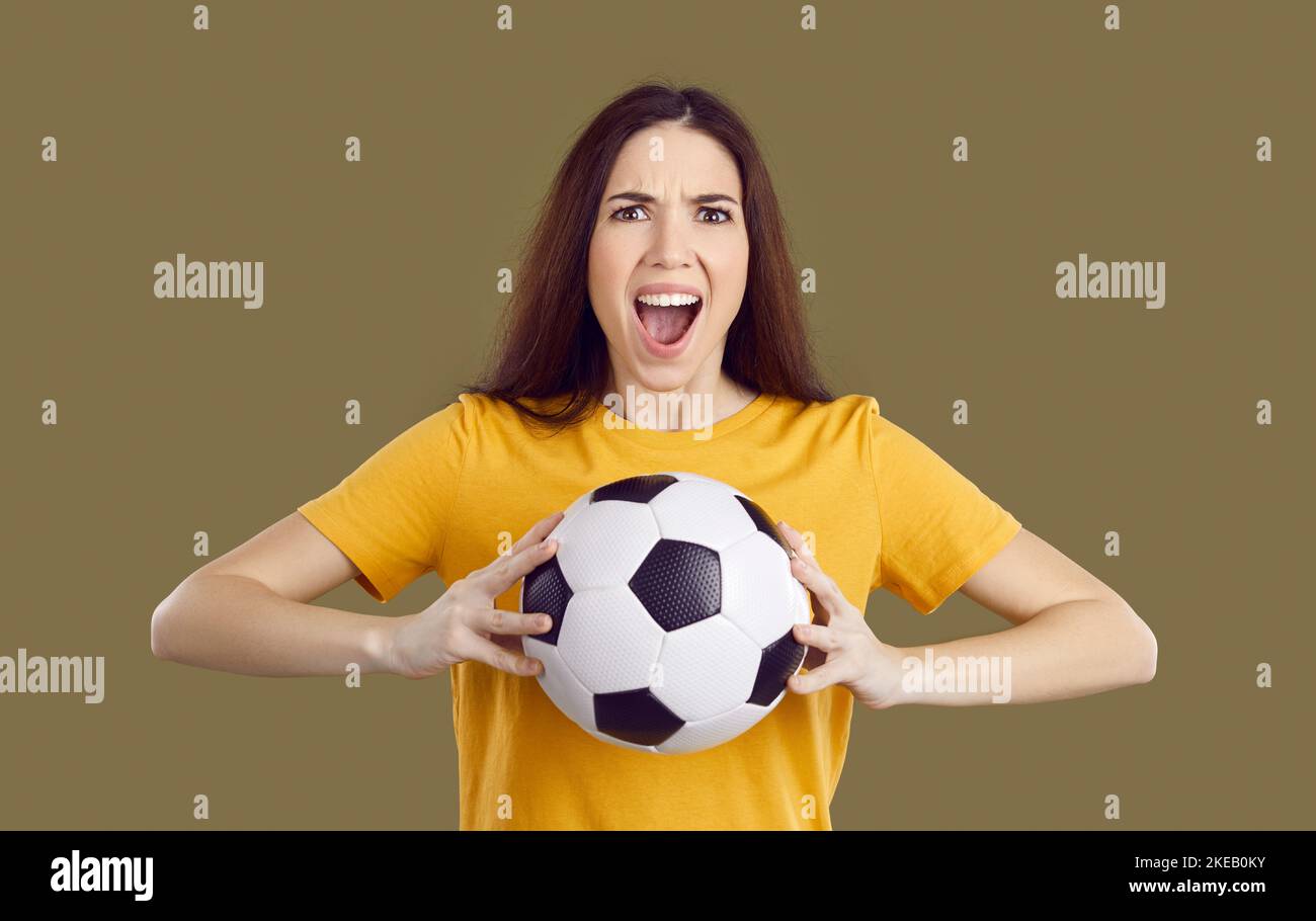 Emotional woman with ball support football team Stock Photo