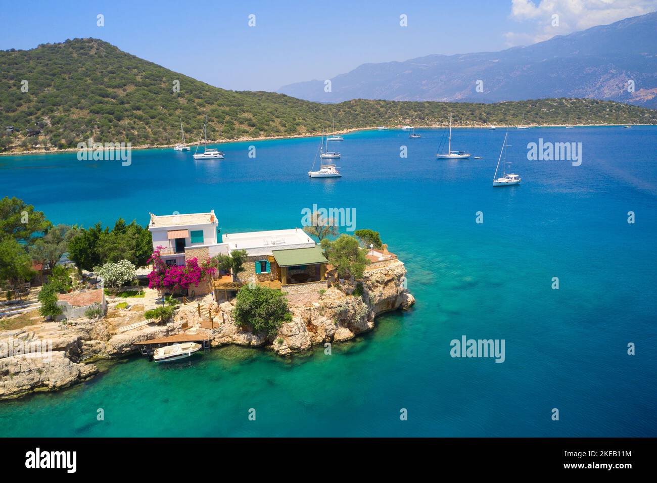 Lonely villa on the coast of the Mediterranean Sea in Turkey, Kas. Aerial view of turquoise water, mountains and yachts Stock Photo