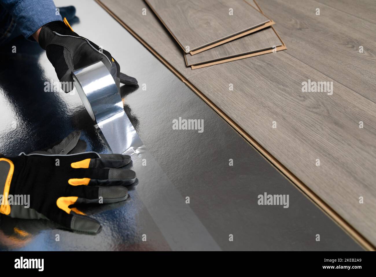 Installation of floating floor, handyman putting underlay for laminate