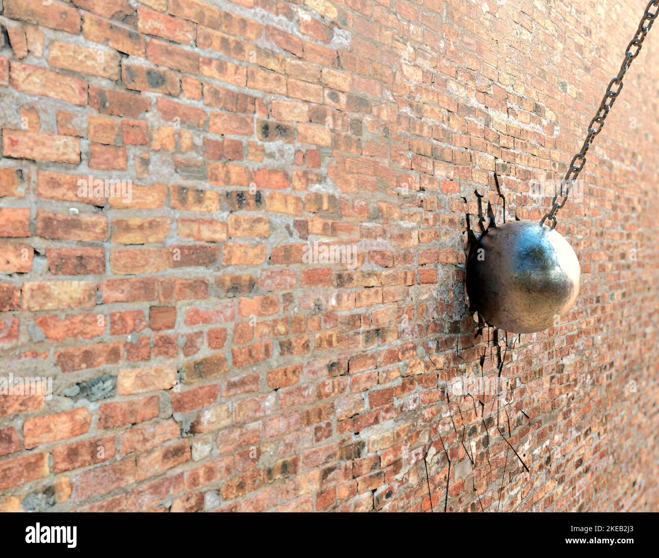 A regular metal wrecking ball attached to a chain breaking a hole in a flat brick wall surface  - 3D render Stock Photo