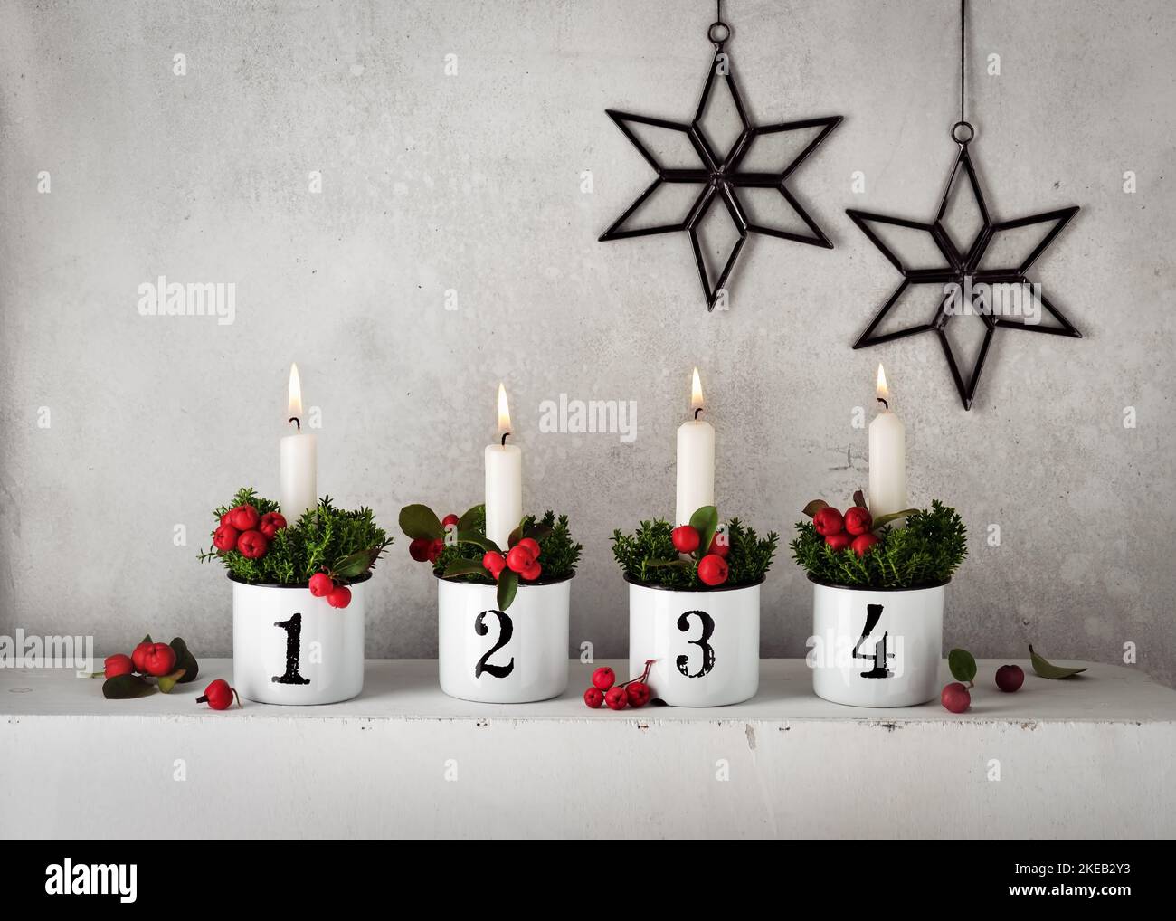 4. Advent. Christmas decorations with white advent candles in four emaile pots with numbers. Handmade home decoration. Selective focus. Copy space. Stock Photo