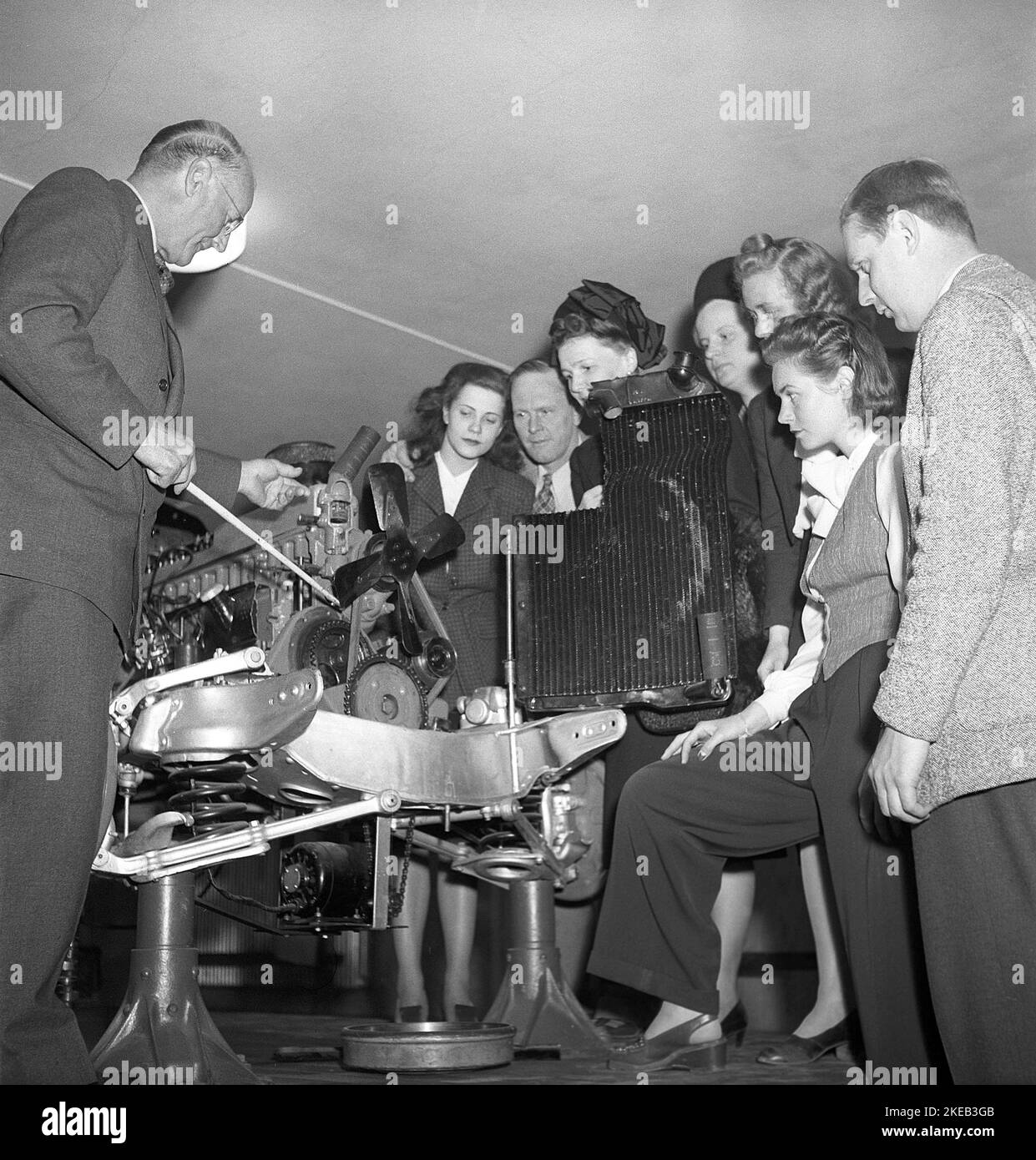 Education in the 1940s. An elderly man is educating a group of younger