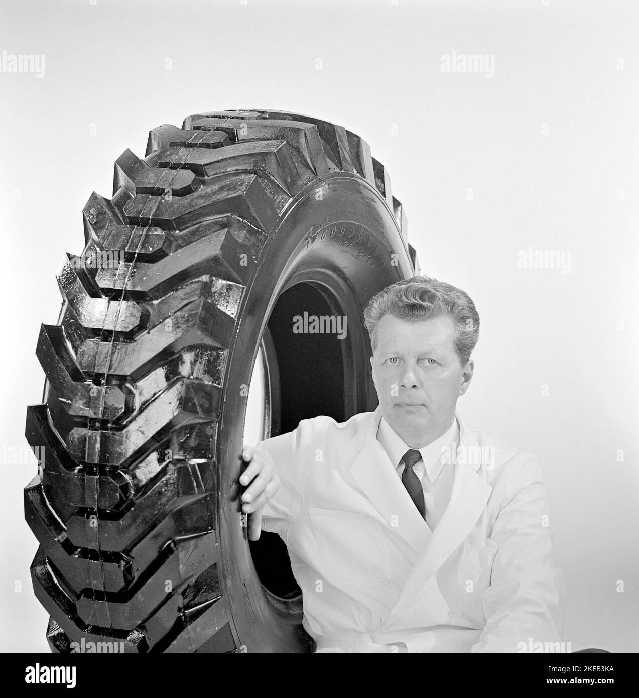 In the 1960s. A man with a large car rubber tire manufactured by Good year. Sweden 1967 Stock Photo