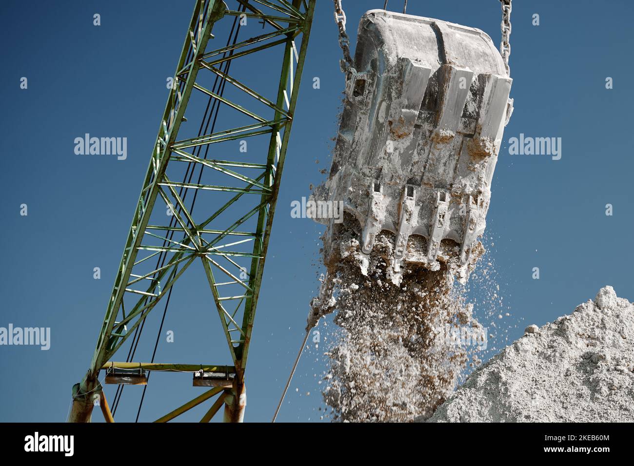 Pouring chalk out of chalk dragline out of bucket at quarry Stock Photo
