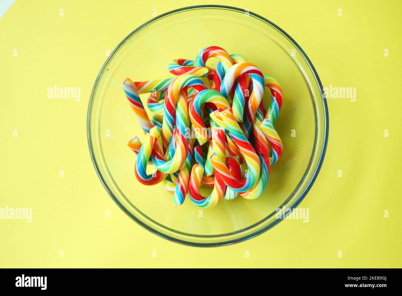 mini cherry candy canes on yellow background Stock Photo