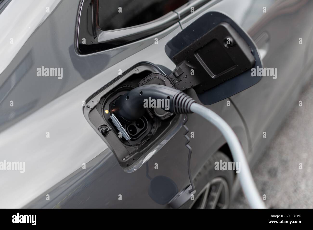 Close up of electric vehicle plug in charge stop - Modern EV charging cable - selective focus vehicle image Stock Photo