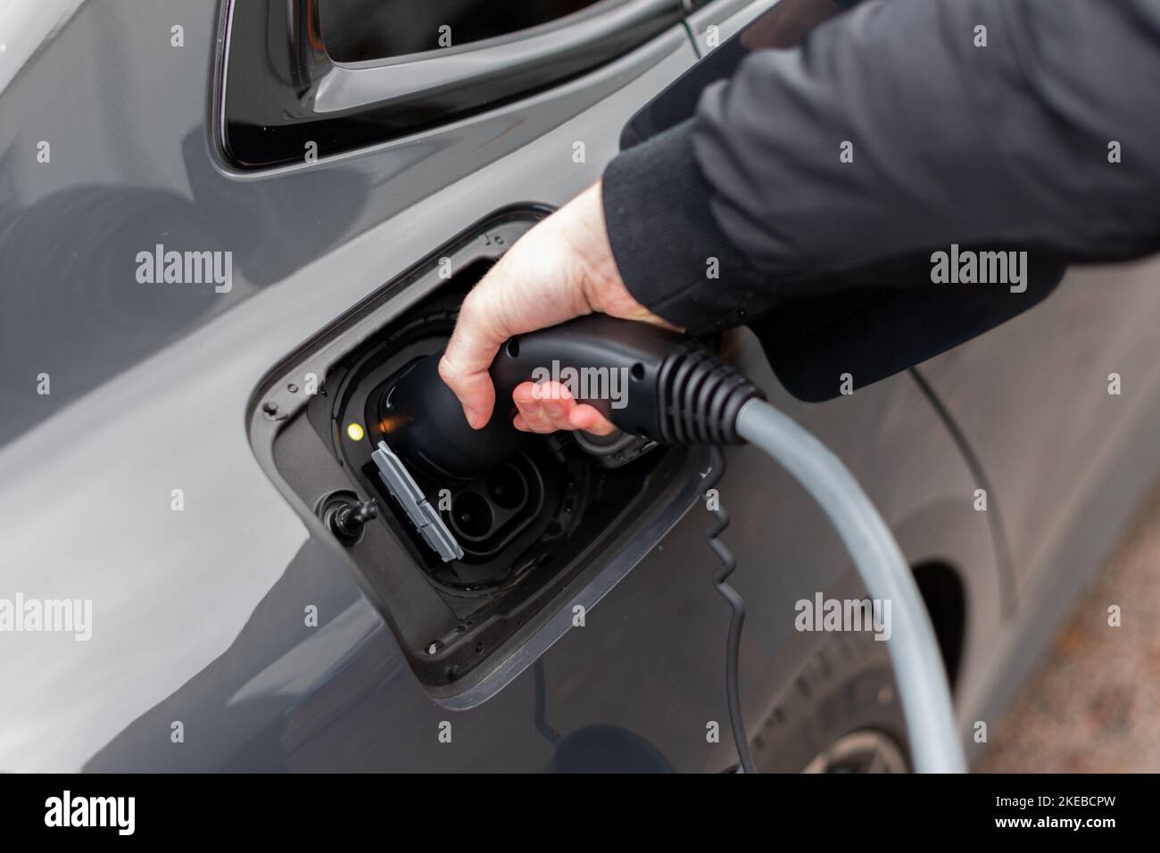 Close up of electric vehicle plug in charge stop Modern EV charging