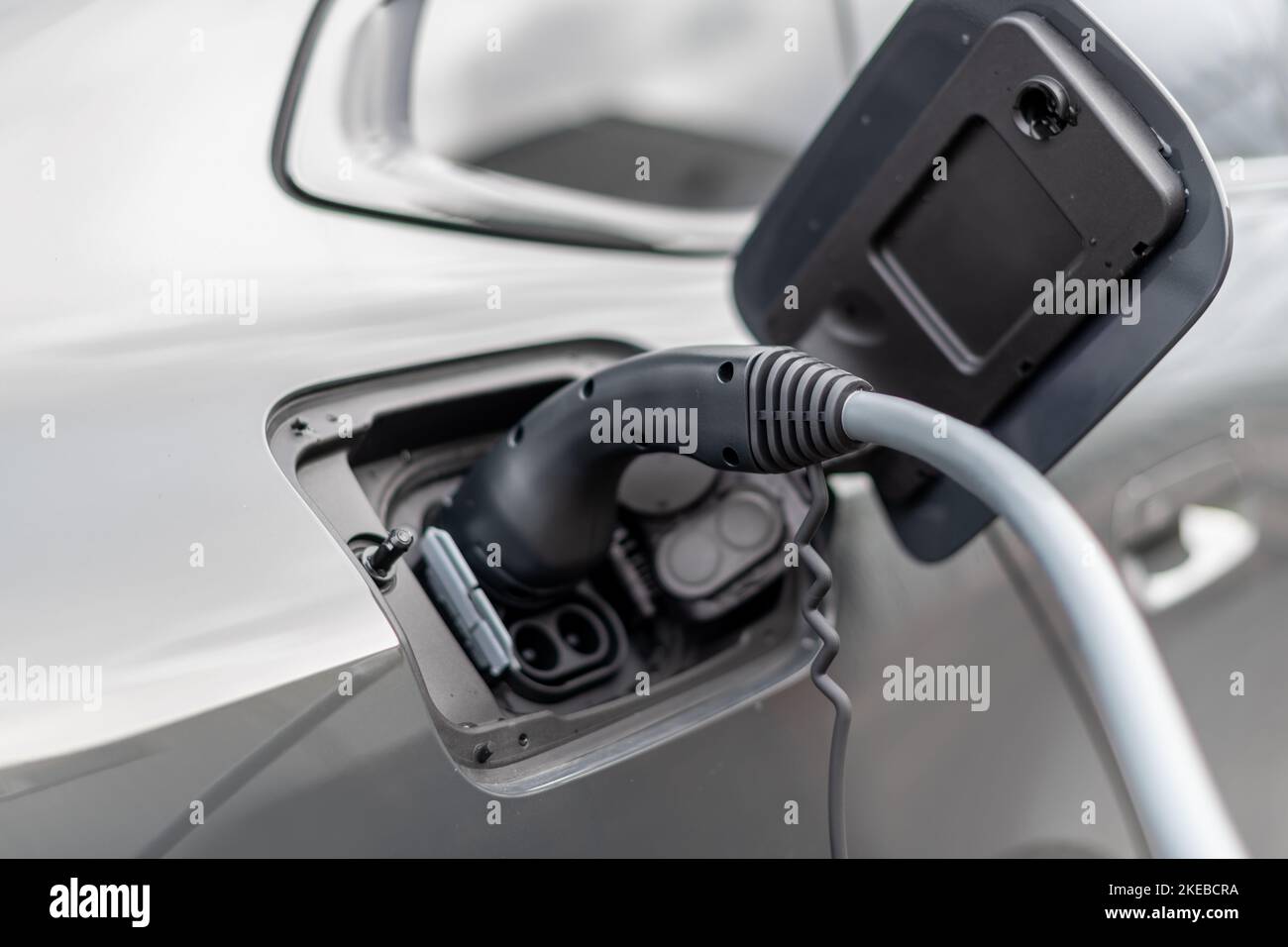 Close up of electric vehicle plug in charge stop - Modern EV charging cable - selective focus vehicle image Stock Photo