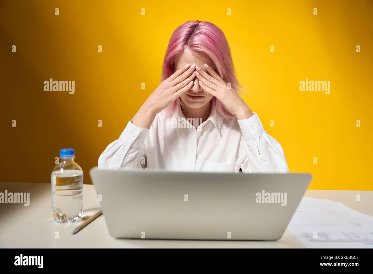 Female working and covering his face with hands Stock Photo