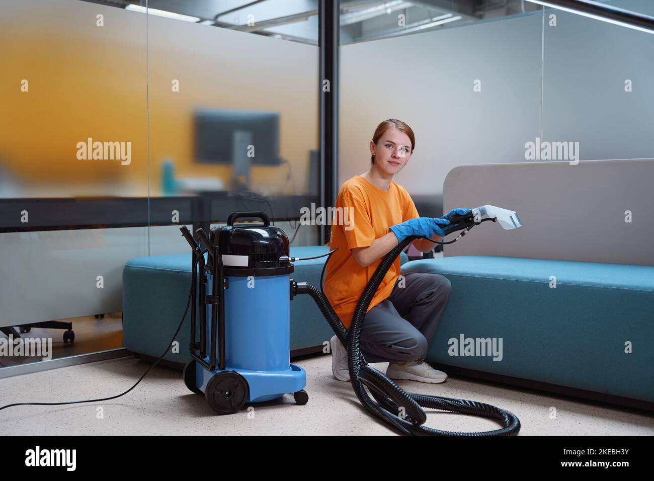 Professional cleaning service worker posing with cleaning equipment
